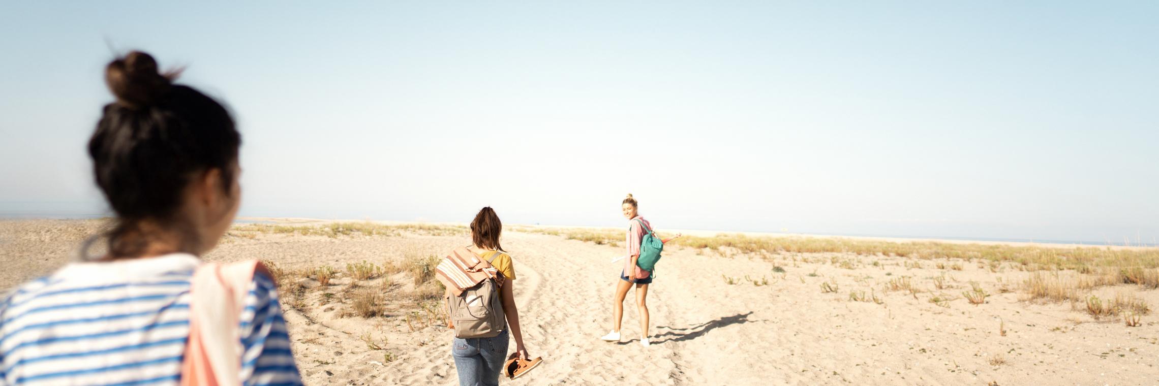 Drei junge Frauen laufen durch die Dünen